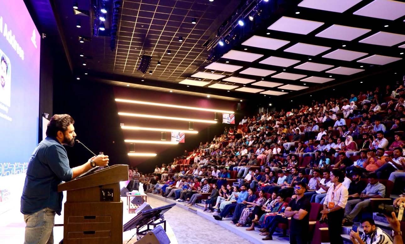 A full house in the Theatre, a speaker at the podium